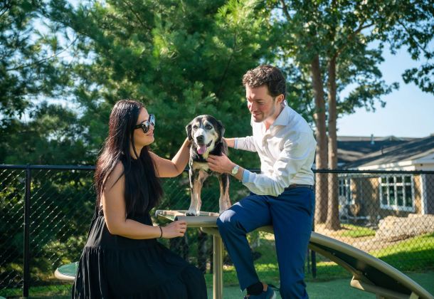 Residents pet a dog on a play structure at The Lofts at Saratoga apartments in Malta, NY.